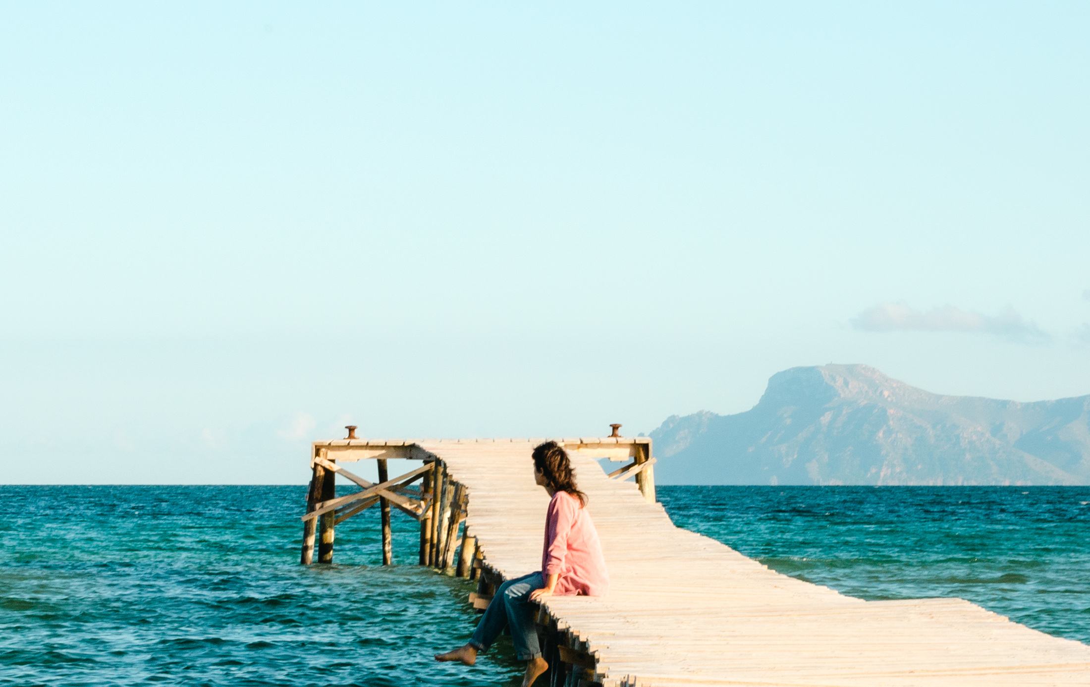 Anne Wolf am Meer, sitzend auf einem Steg, Mallorca